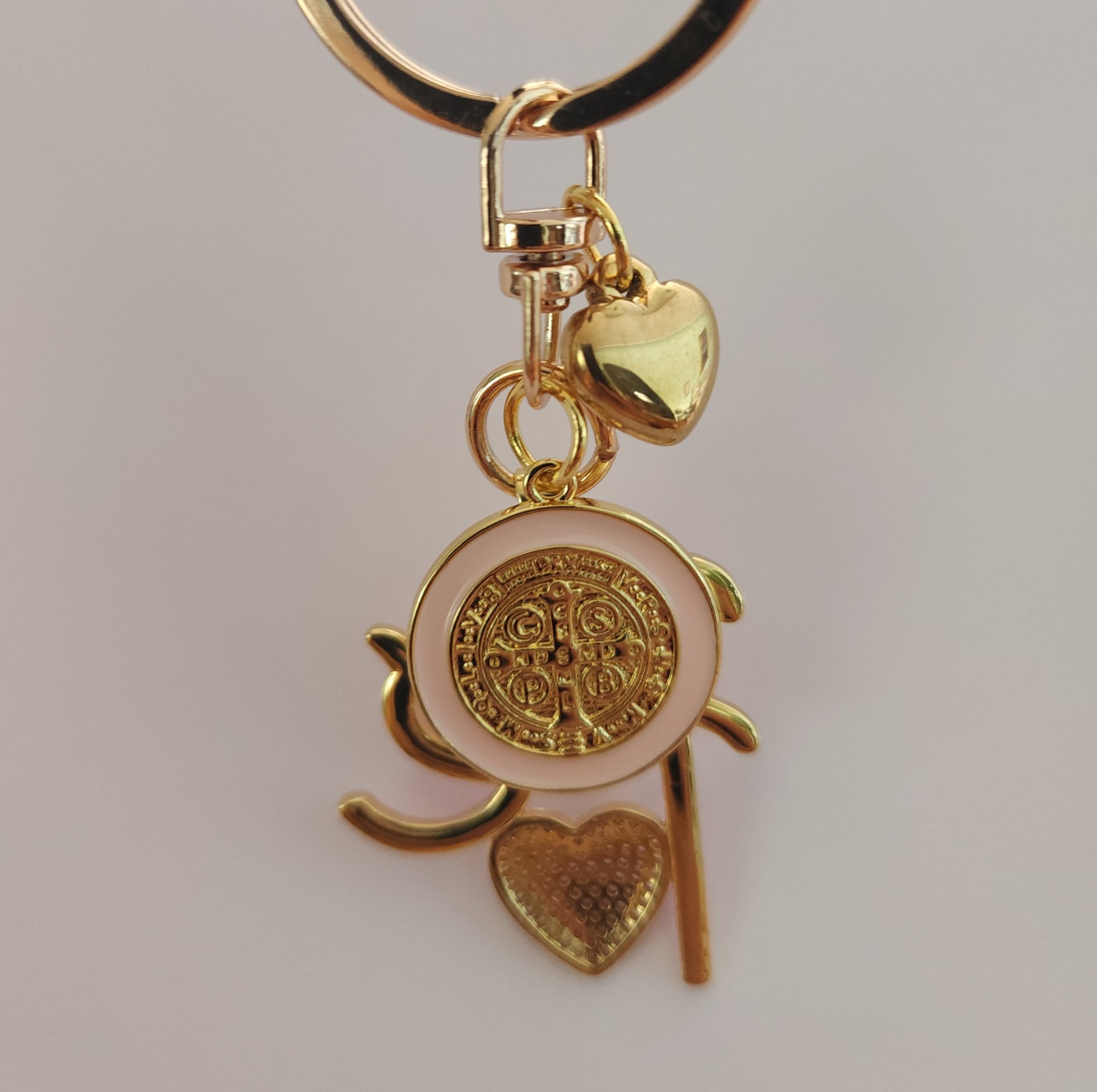 St. Benedict faith keychain with Fe charm and gold heart, 18k gold plated medal on neutral background