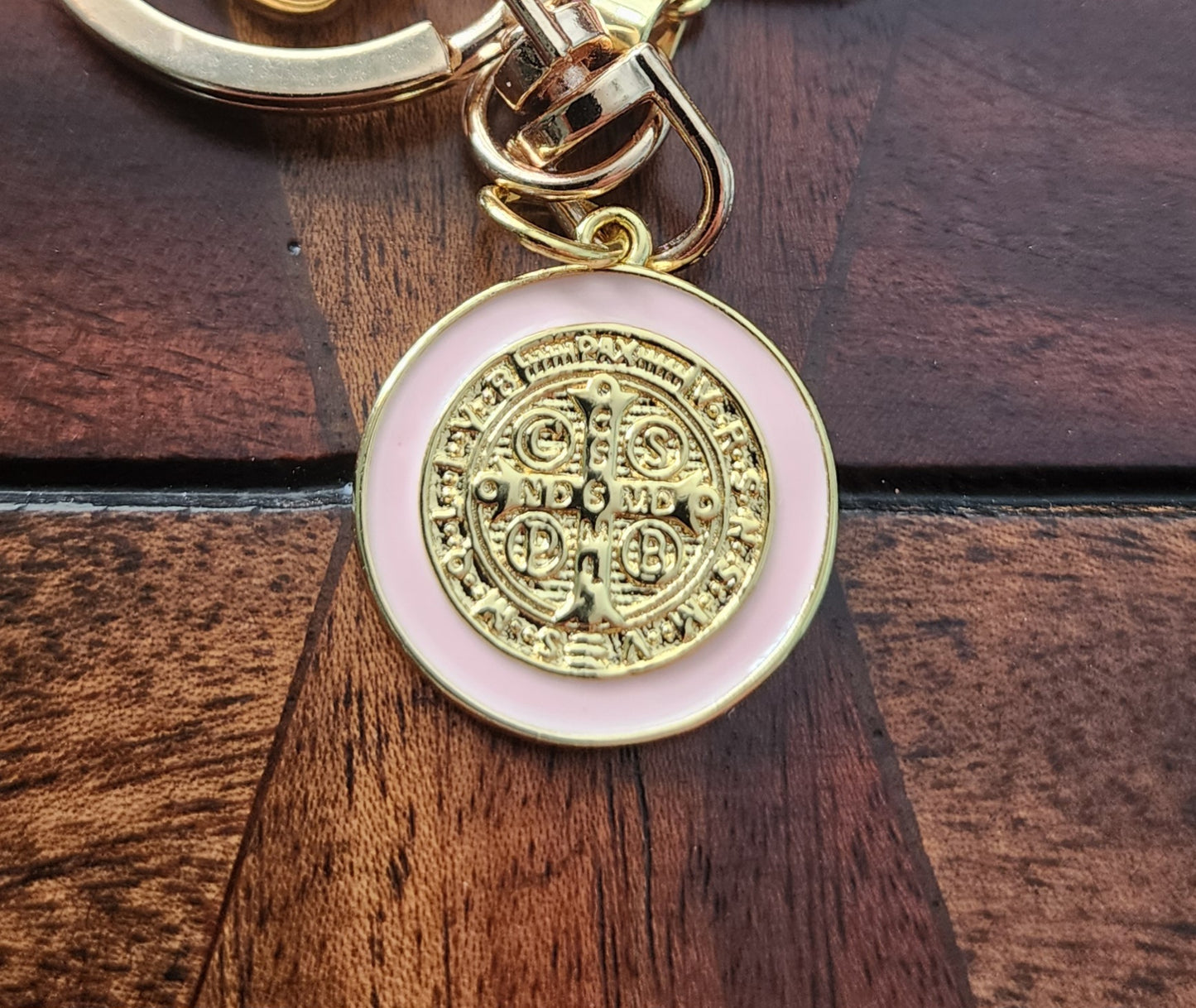 Close-up of St. Benedict medal keychain showing gold plating and textured heart charm
